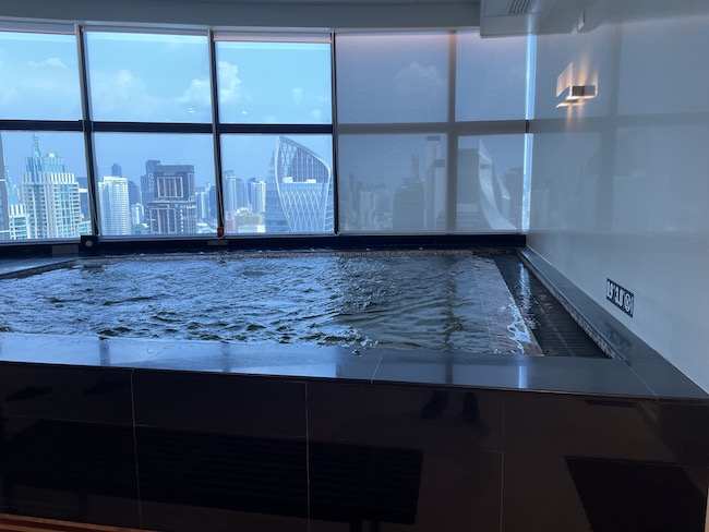 a pool in a room with a large window and city view