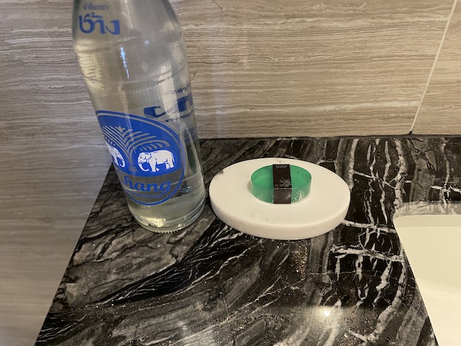 a bottle of water and a soap dish on a marble counter