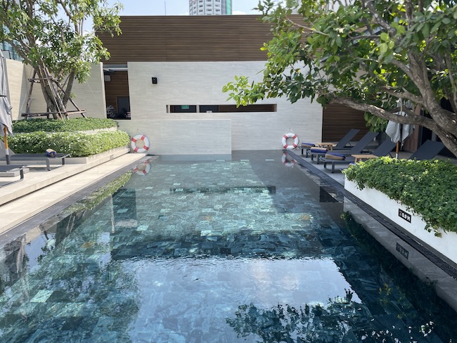 a pool with chairs and trees