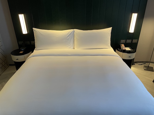 a bed with white sheets and pillows