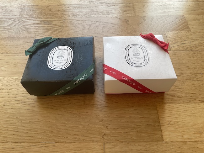 two boxes with ribbons on a wood surface