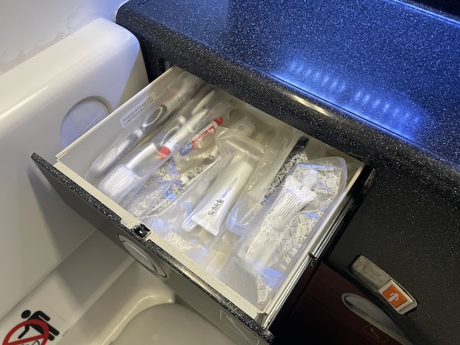 a drawer with toothbrushes and toothpaste inside