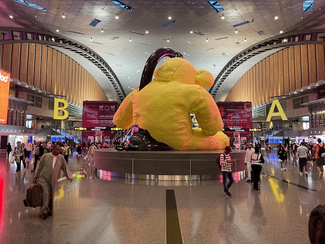 a large yellow stuffed bear statue in a large building