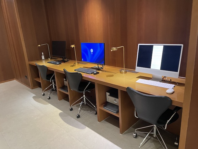 a desk with computers and chairs