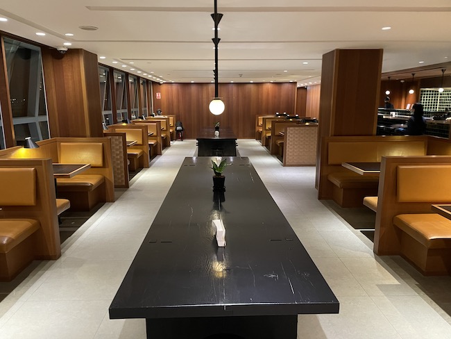 a long black table in a room with benches and lights