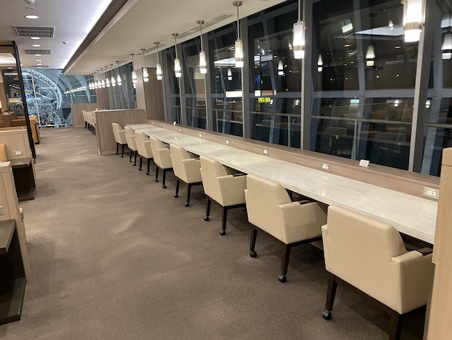 a long table with chairs in a room with windows
