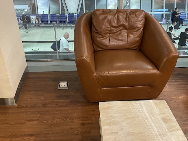 a brown leather chair in front of a glass wall