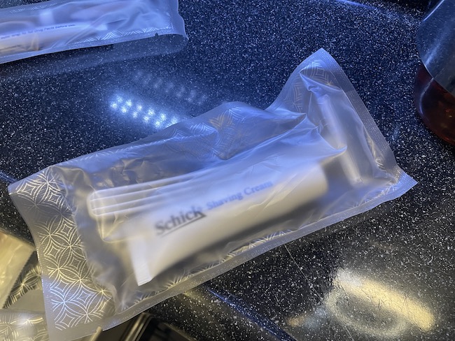 a plastic bag with a white tube and razor sticks on it