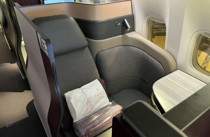 qatar-qsuite-741 - 1 a seat with a white pillow on it