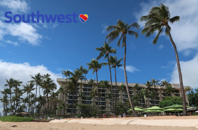 a building with palm trees and umbrellas on a beach