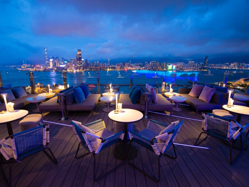 a rooftop bar with a city skyline in the background