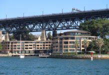 a bridge over water with buildings and trees