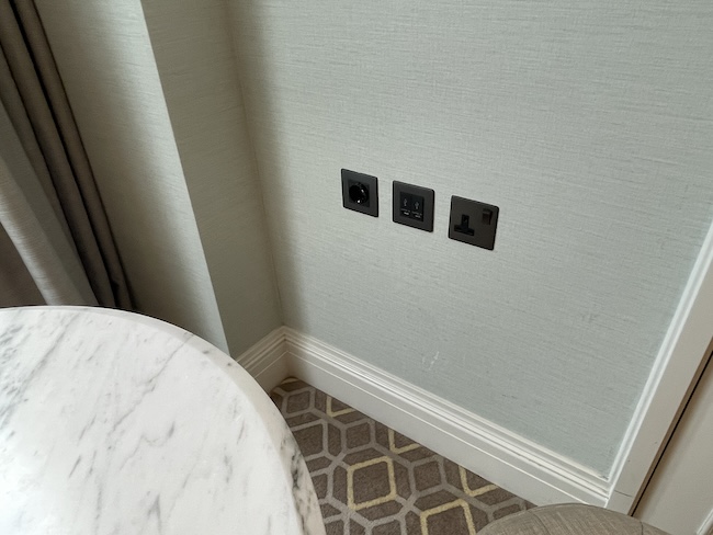 a wall with electrical outlets and a table