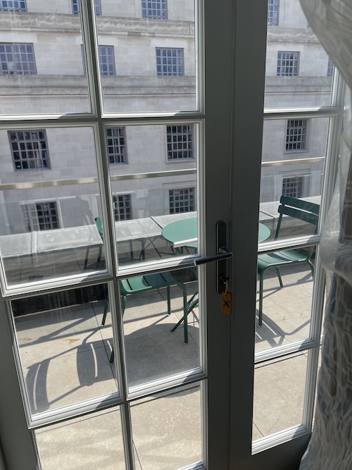 a glass door with a table and chairs outside