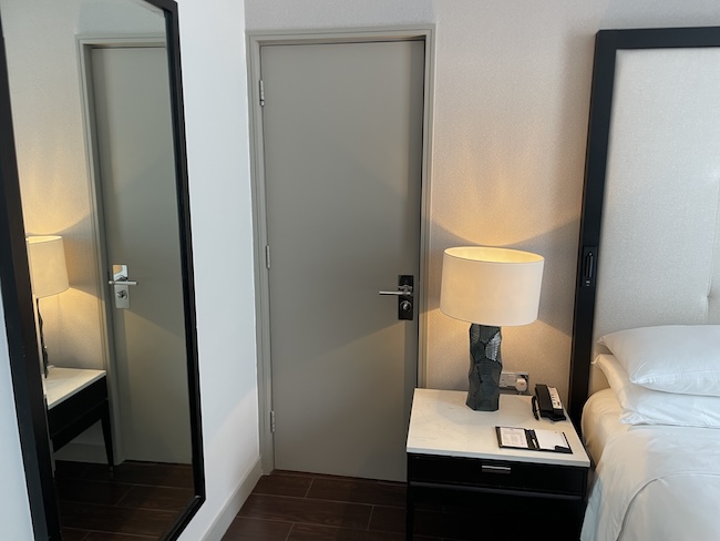 a bedroom with a door and a mirror