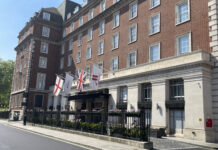 a building with flags and a fence