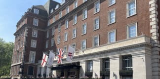 a building with flags and a fence