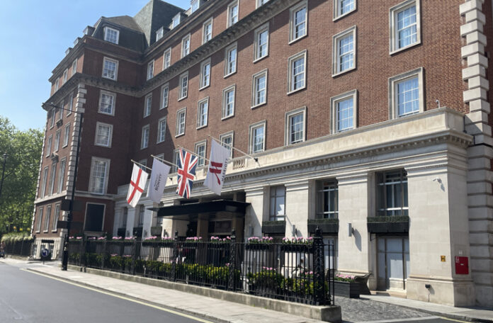 a building with flags and a fence