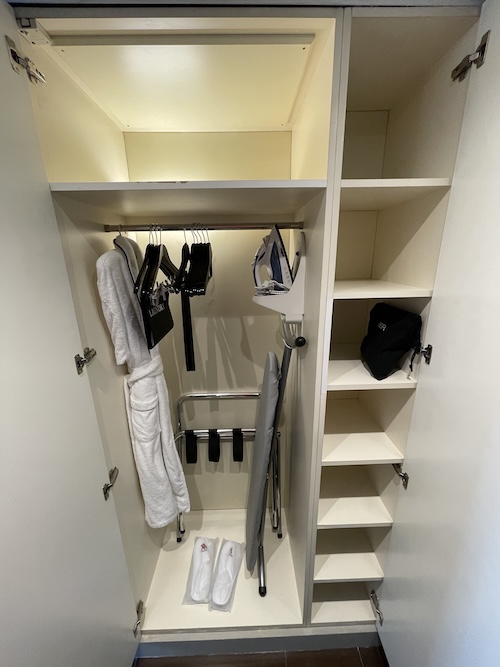 a closet with white shelves and white robe