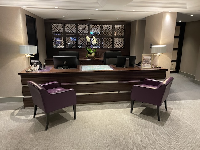 a desk with purple chairs and a lamp