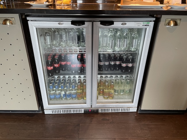 a refrigerator with bottles of soda