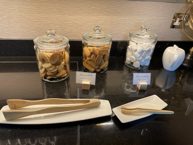 a table with jars of cookies and marshmallows