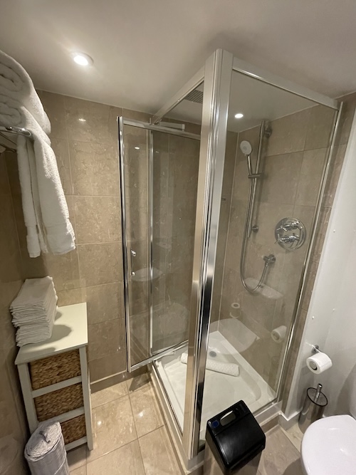 a bathroom with a glass shower and a white towel