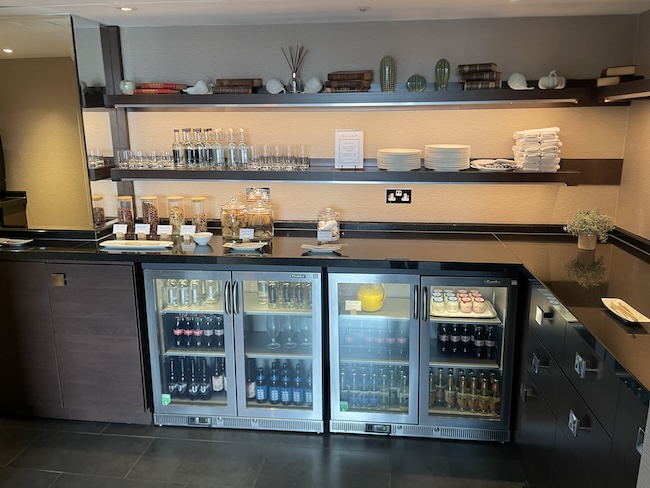 a fridge with drinks and shelves in a room