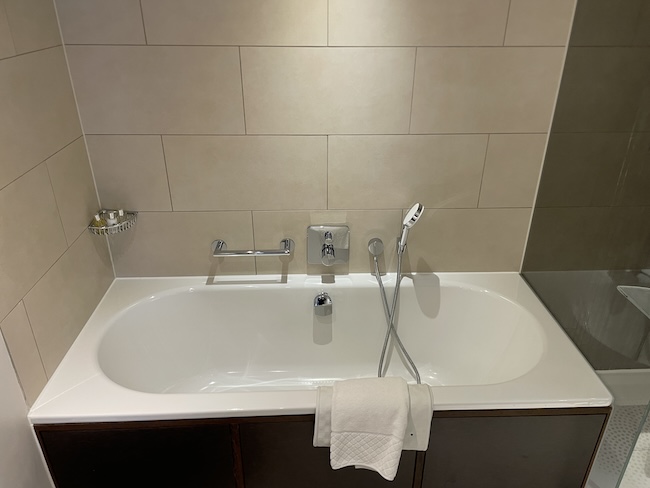 a bathtub with a shower head and a towel