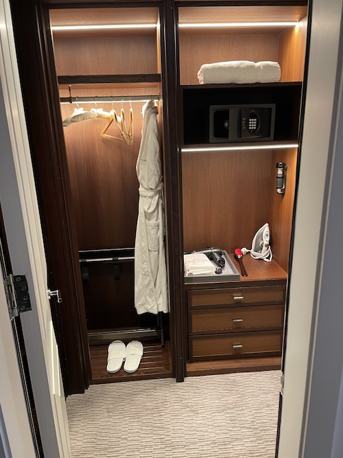 a closet with a white robe and a door