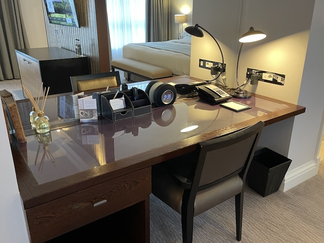 a desk with a phone and a lamp