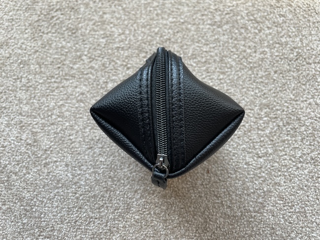 a black leather pouch on carpet