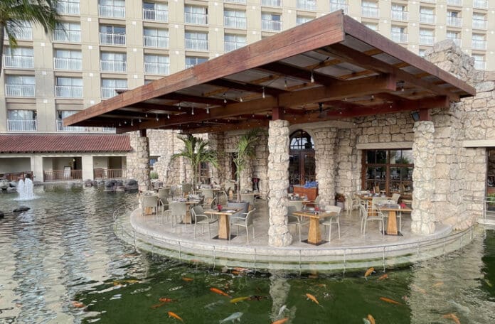 a restaurant with a pond and fish in the water