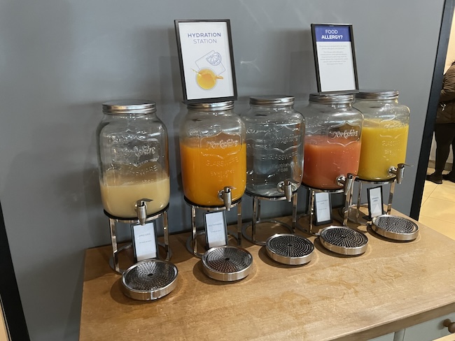 a row of juice dispensers on a table