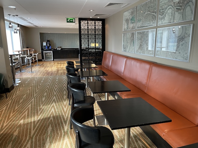 a long booth with tables and chairs in a room