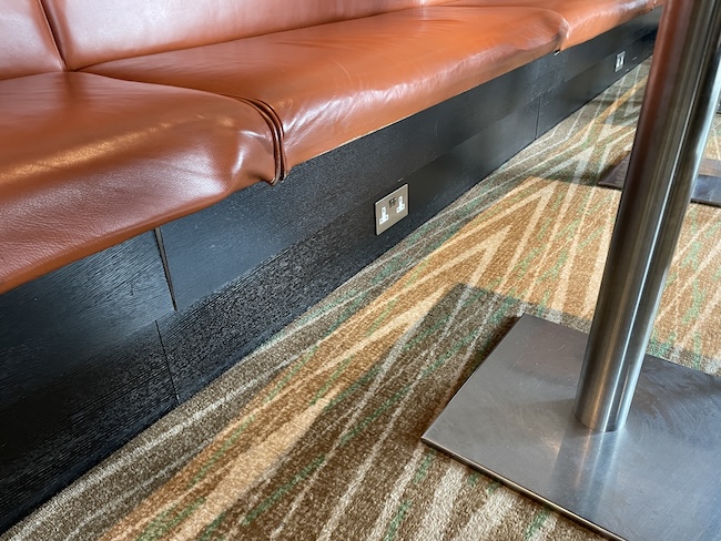 a brown leather couch with a metal pole