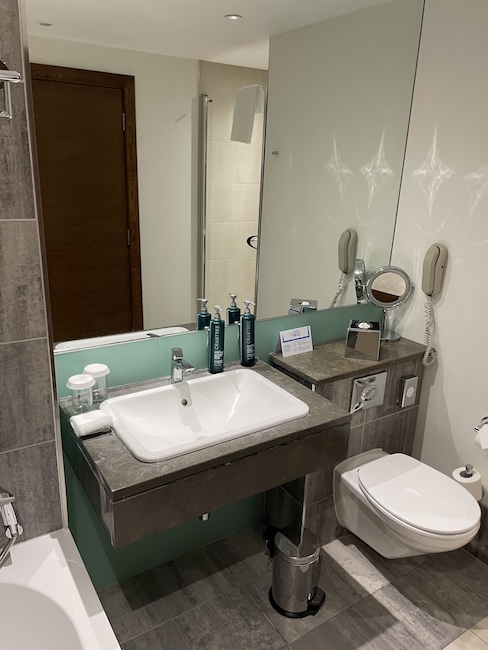 a bathroom with a sink toilet and mirror