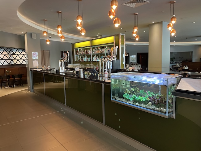 a bar with fish tank and shelves