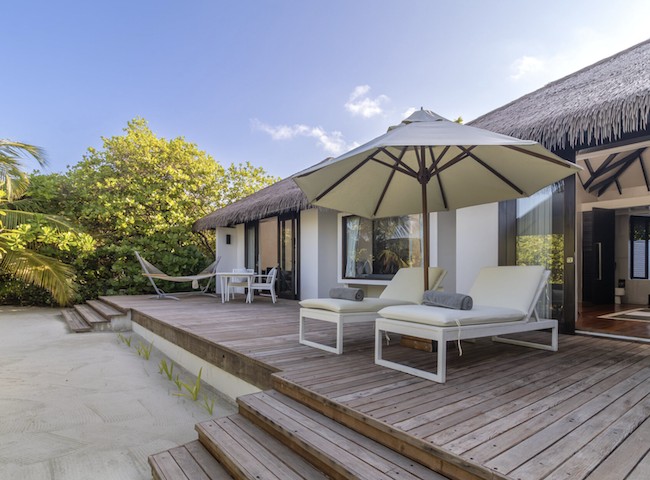 a deck with chairs and umbrella on a deck