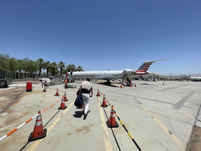 a person running on a runway with a plane in the background