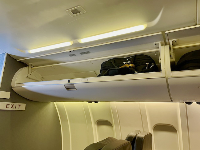 luggage in an airplane with a shelf