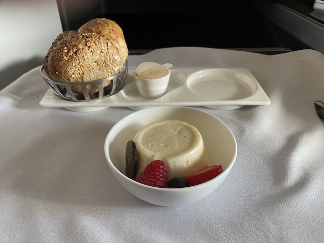 a bowl of fruit and a bread on a tray