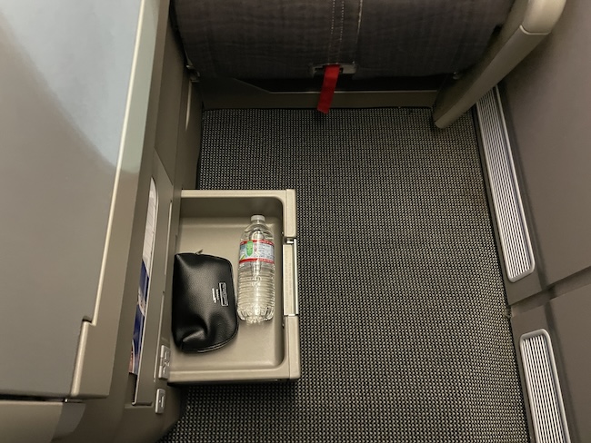 a small drawer with a bottle and a wallet in it