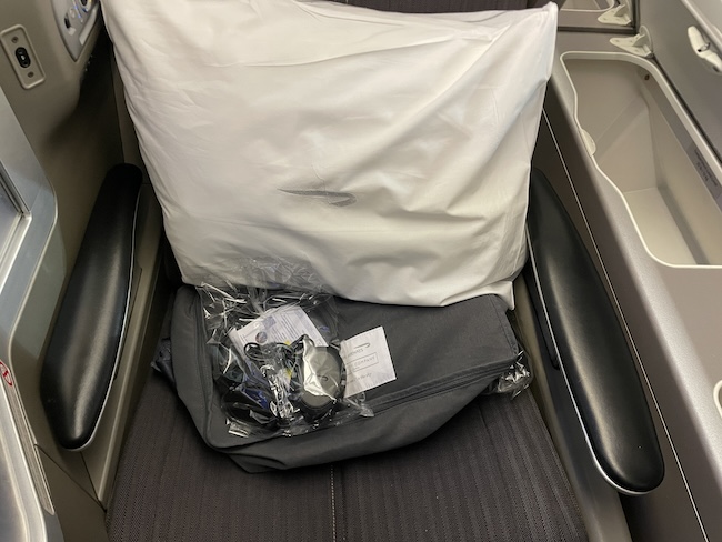 a white pillow and a bag on a seat