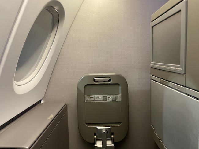 an airplane seat with a window and a door