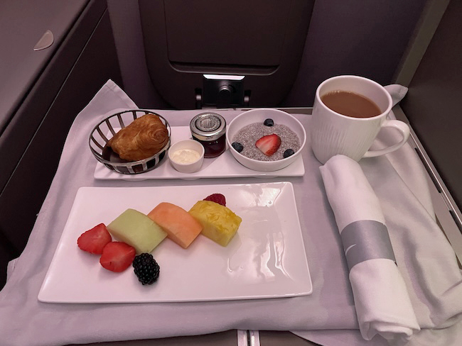 a plate of fruit and a cup of coffee on a table