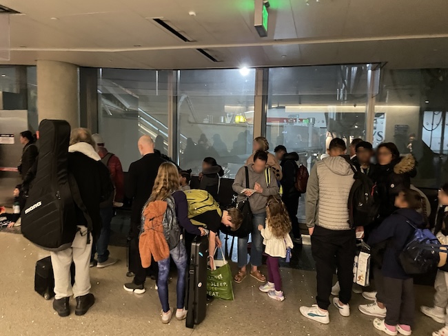 a group of people standing in a room with windows