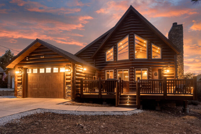 a log cabin with a garage and a driveway