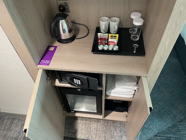 a small cabinet with a small tray of food and a coffee pot