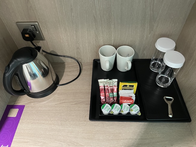 a tray with coffee cups and condiments on a table